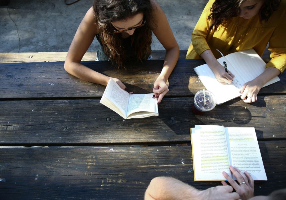 Three people sitting around a table, engaged in conversation.