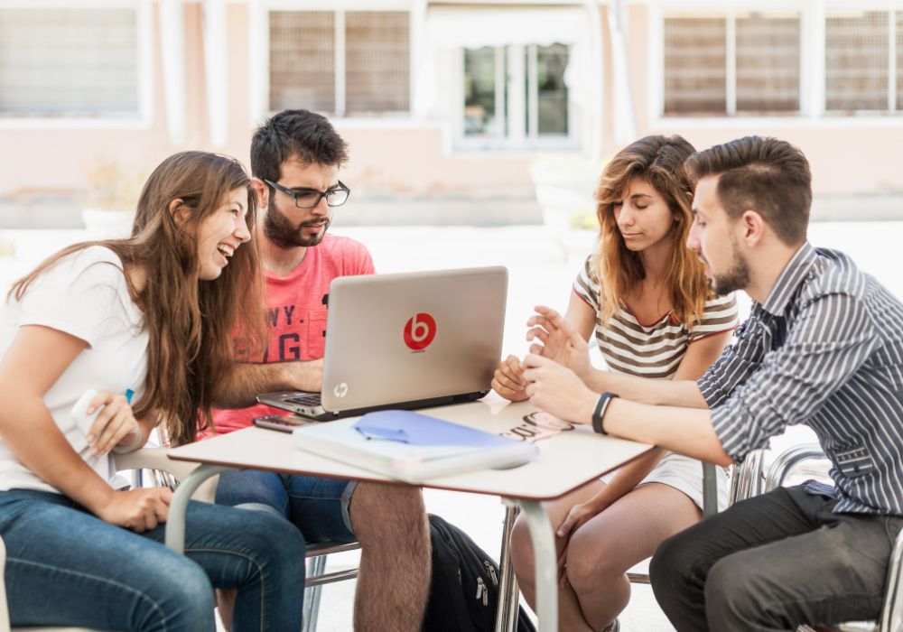 A group of students engaged with a laptop.